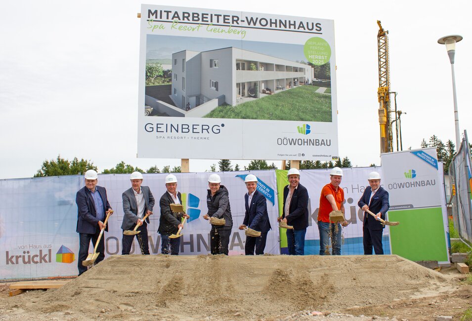 Spatenstich für Mitarbeiterwohnhaus in Geinberg mit Gruppe von Personen und Bauschild