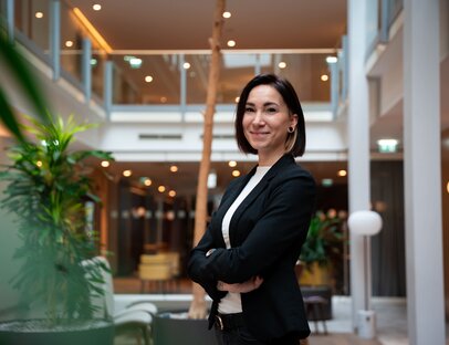 Lisa Kuba, Eventmanagerin, trägt einen schwarzen Blazer im Foyer