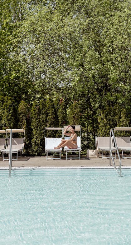 Frau im Bikini auf Sonnenliege am Pool