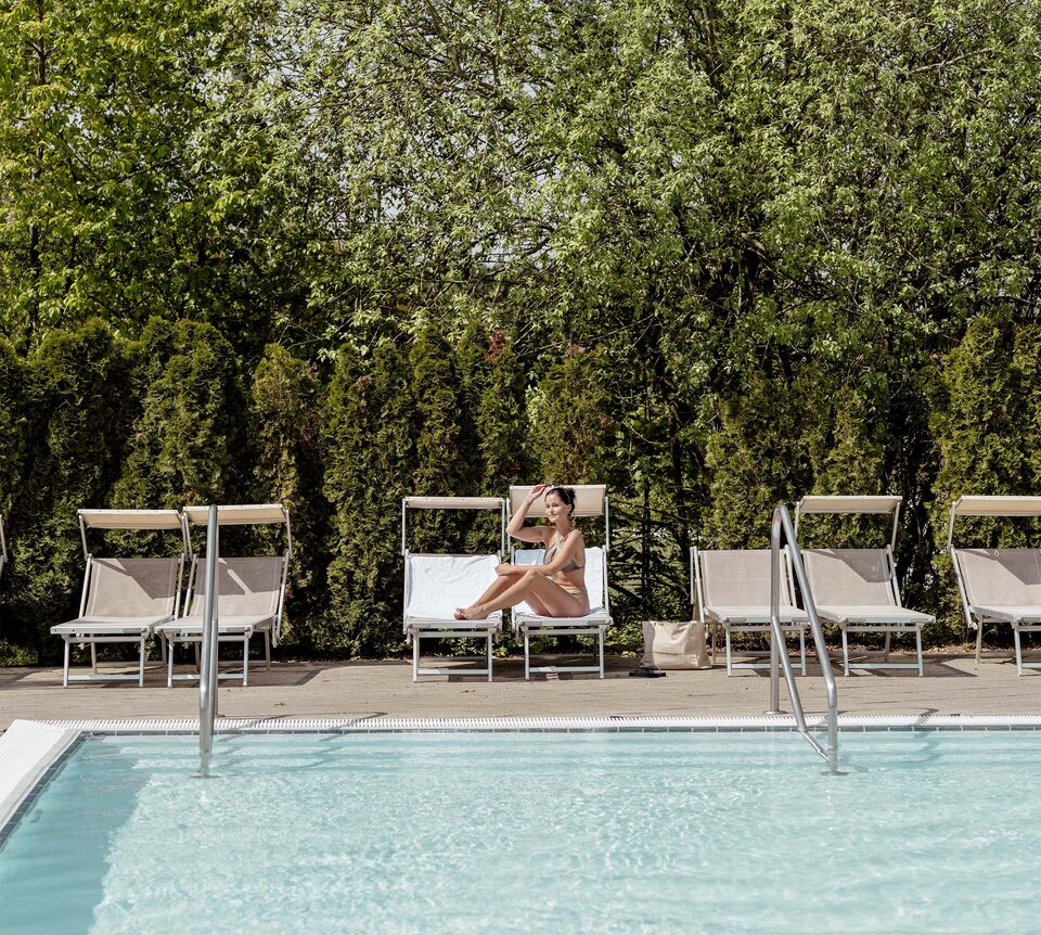 Frau im Bikini auf Sonnenliege am Pool