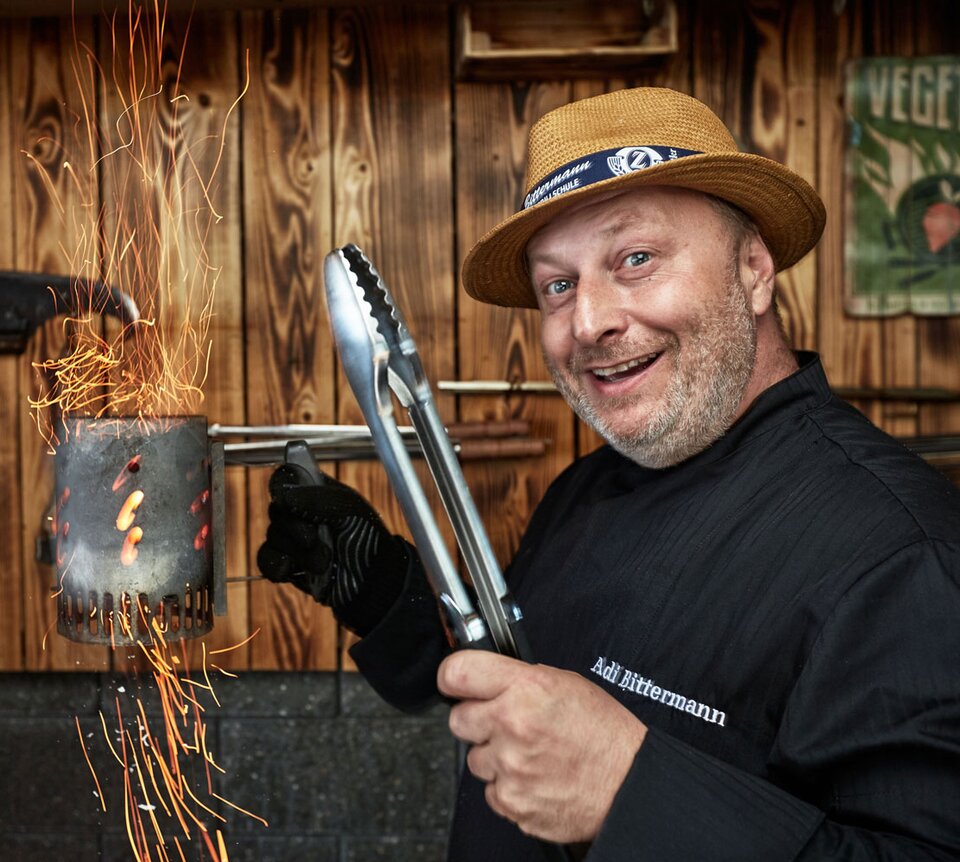 Grillweltmeister Adi Bittermann mit Grillwerkzeug und Feuer | © Adi Bittermann
