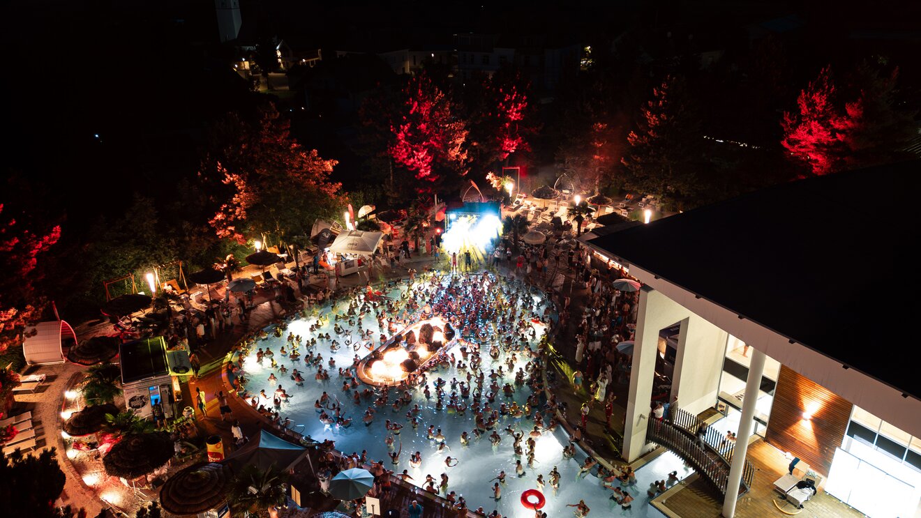 Beleuchtete Poolparty mit vielen Menschen bei Nacht | © Spa Resort Geinberg / Tobi Gast