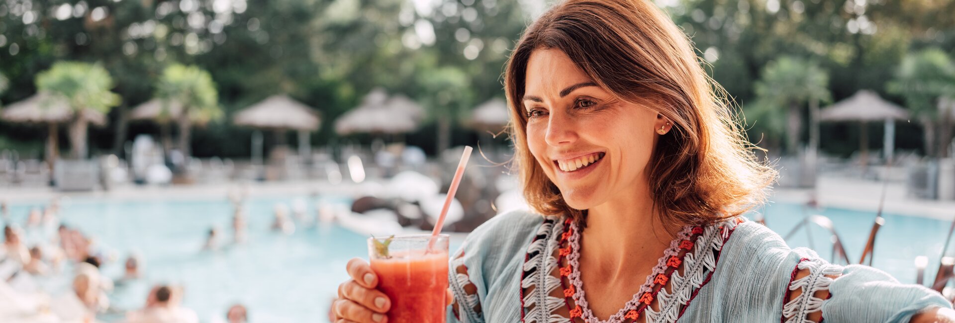 Brünette Frau genießt einen exotischen Cocktail an der Karibik-Bar im Spa Resort Geinberg  | © Spa Resort Geinberg / Chris Perkles