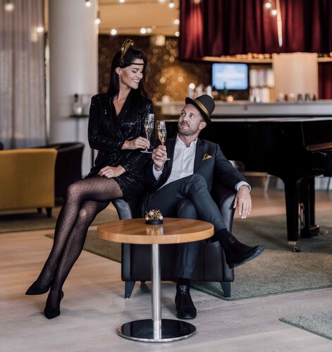 Passend zu den golden 20ies gekleidetes Paar stoßt in der Hotelbar auf das neue Jahr an | © Spa Resort Geinberg / Chris Perkles 