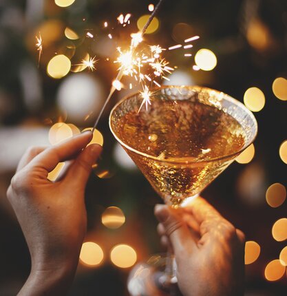 Champagner-Glas mit einer feierlichen Wunderkerze | © Shutterstock / Bogdan Sonjachnyj