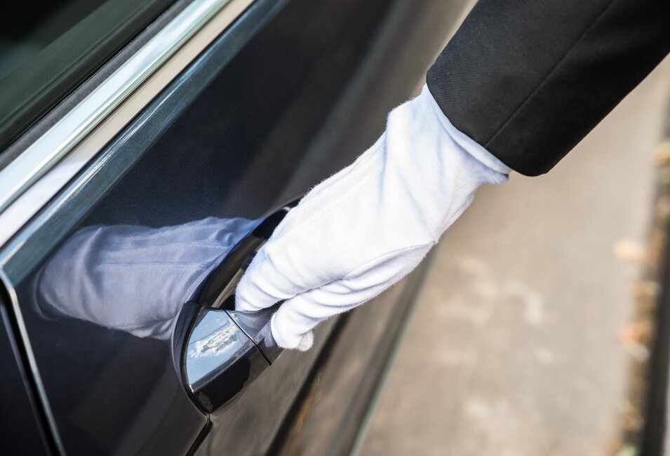 Behandschuhte Hand an dunkler Autotür