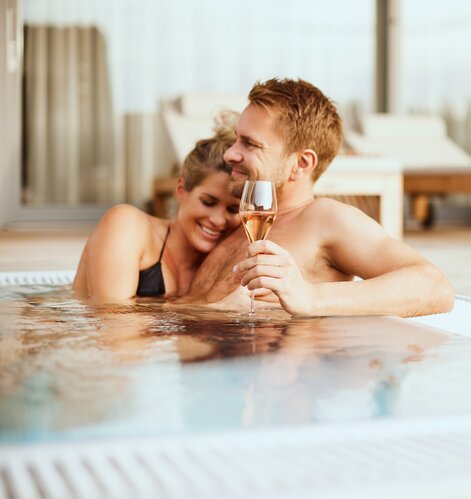 Verliebtes Paar entspannt mit einem Glas Champagner im Whirlpool der Geinberg5 Private Spa Villas | © Spa Resort Geinberg / Julia Traxler