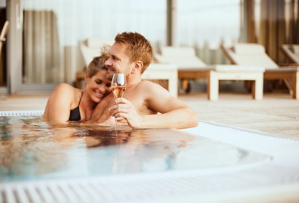 Verliebtes Paar entspannt mit einem Glas Champagner im Whirlpool der Geinberg5 Private Spa Villas | © Spa Resort Geinberg / Julia Traxler