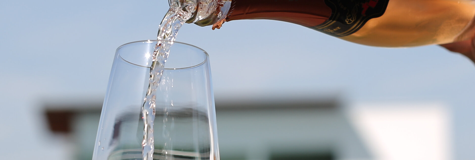 Private Butler gießt Champagner in ein Glas mit dem Private Spa im Hintergrund | © Spa Resort Geinberg