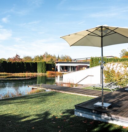 Geinberg5 Private Spa Villas im Herbst: Außenansicht mit Pool, Liegen, Sonnenschirm und gepflegtem Garten | © Spa Resort Geinberg / Tobi Gast
