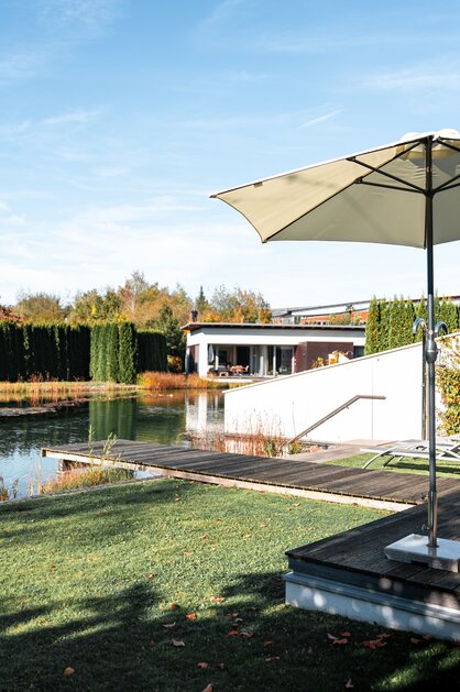 Geinberg5 Private Spa Villas im Herbst: Außenansicht mit Pool, Liegen, Sonnenschirm und gepflegtem Garten | © Spa Resort Geinberg / Tobi Gast