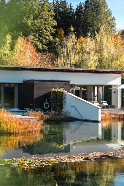 Moderne Villa am See im Herbstwald mit Spiegelung im Wasser | © Spa Resort Geinberg / Tobi Gast