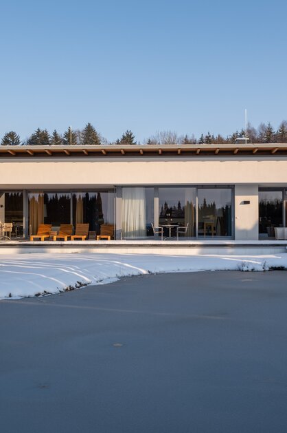 Moderne Villa am See im Winter mit Schnee und Eis | © Spa Resort Geinberg / Chris Perkles