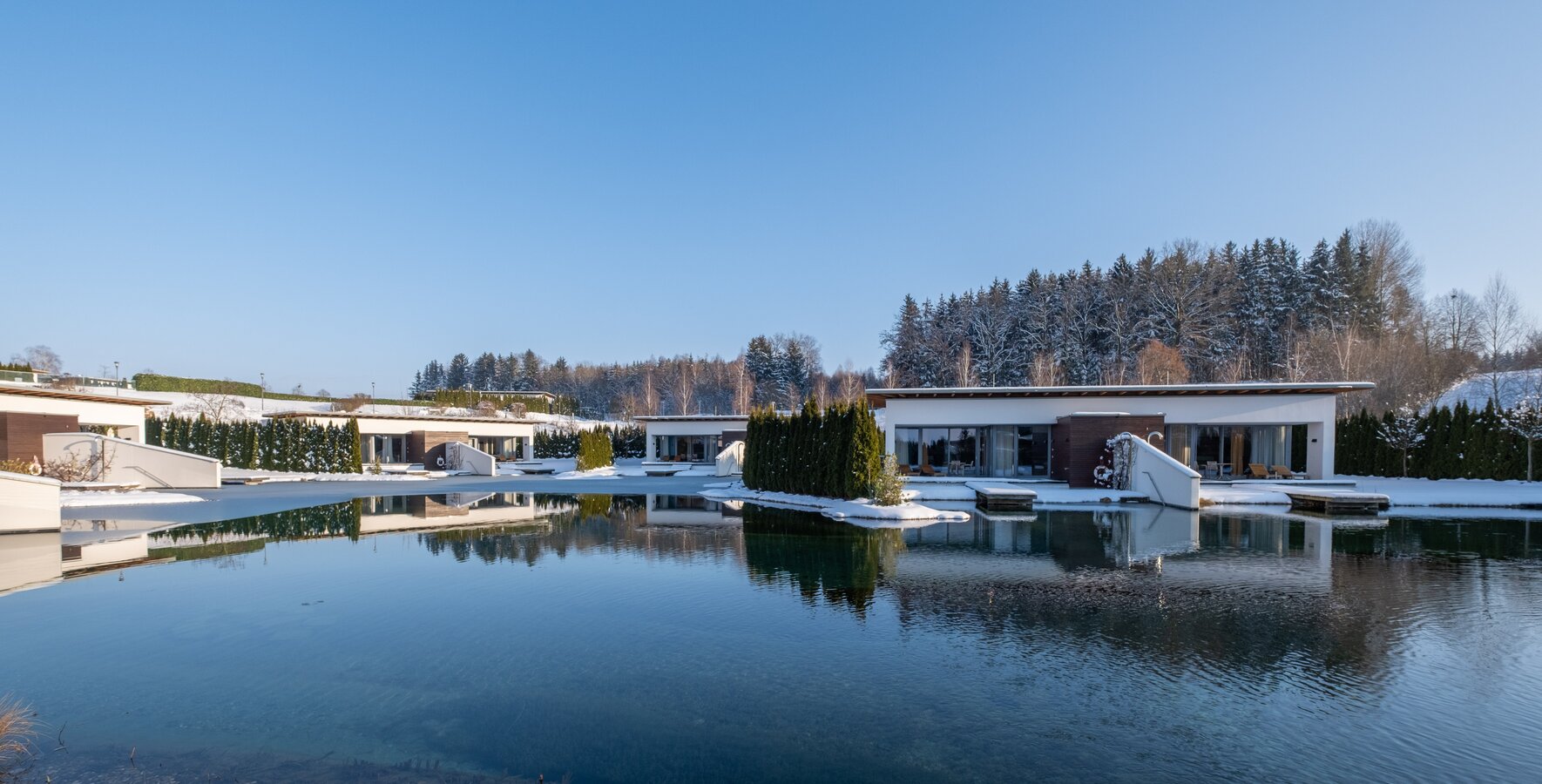 Geinberg5 Private Spa Villas rund um den Naturbadeteich in Schneelandschaft | © Spa Resort Geinberg / Chris Perkles