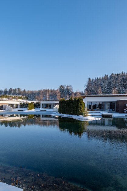 Geinberg5 Private Spa Villas rund um den Naturbadeteich in Schneelandschaft | © Spa Resort Geinberg / Chris Perkles