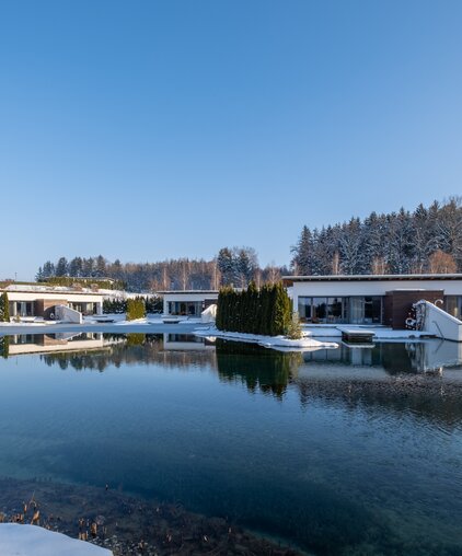 Geinberg5 Private Spa Villas rund um den Naturbadeteich in Schneelandschaft | © Spa Resort Geinberg / Chris Perkles