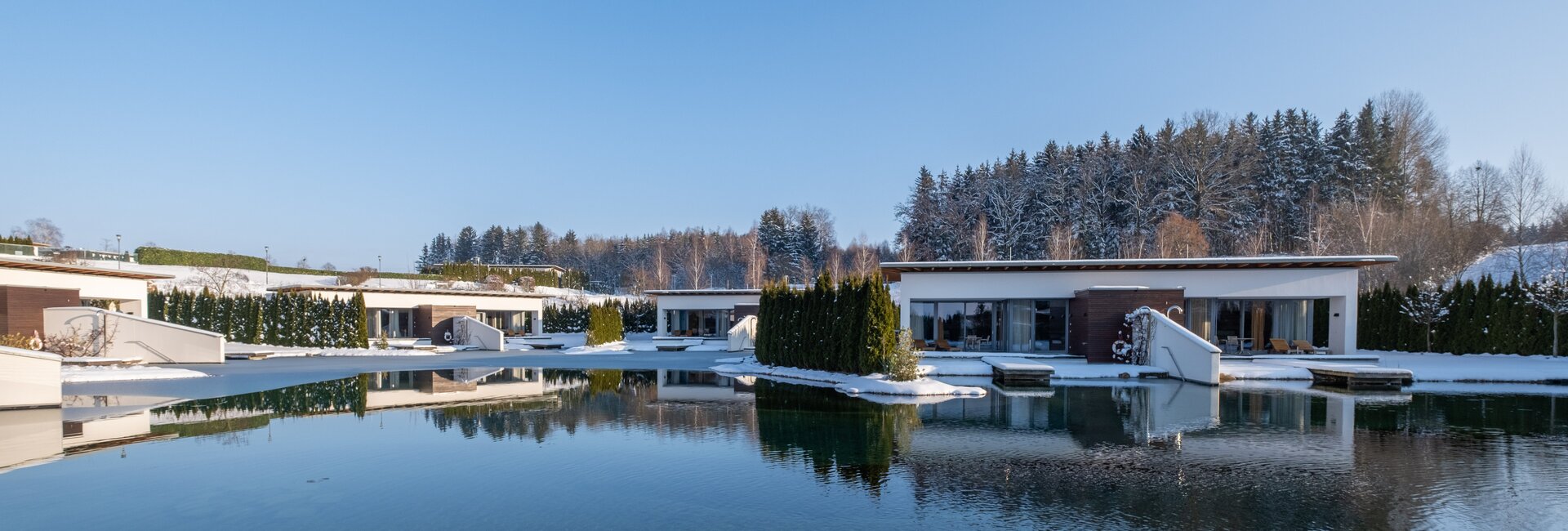 Geinberg5 Private Spa Villas rund um den Naturbadeteich in Schneelandschaft | © Spa Resort Geinberg / Chris Perkles