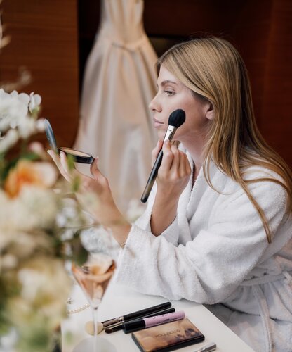 Blonde Frau trägt in den Geinberg5 Private Spa Villas Make-up für ihren Hochzeitstag auf | © Spa Resort Geinberg / Chris Perkles