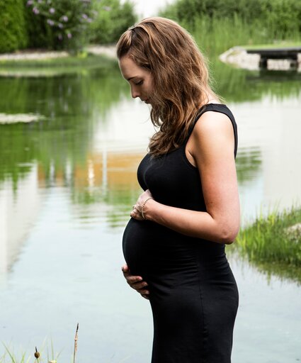 Schwangere Frau im schwarzen Kleid am Teich | © Spa Resort Geinberg / Juliane Mayr
