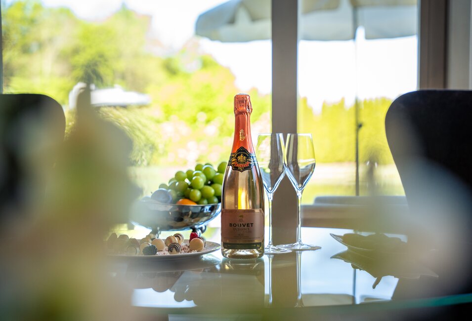 Gedeckter Tisch mit Champagner, Obst und Pralinen in den Geinberg5 Private Spa Villas | © Spa Resort Geinberg / Tobi Gast