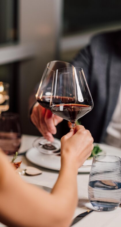 Paar beim Anstoßen mit Rotwein im Kerzenschein | © Spa Resort Geinberg / Chris Perkles