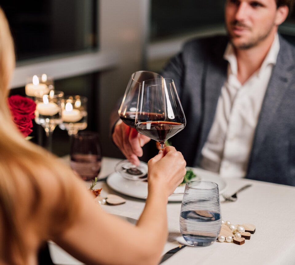 Paar beim Anstoßen mit Rotwein im Kerzenschein | © Spa Resort Geinberg / Chris Perkles