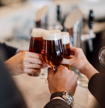 Gläser mit köstlichem Bier stoßen bei der Bierverkostung an der Hotelbar des Spa Resort Geinberg miteinander an | © Spa Resort Geinberg / Chris Perkles