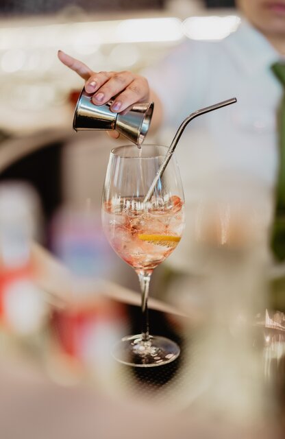 Kompetente Mitarbeiterin verfeinert einen exquisiten Drink an der Hotelbar des Spa Resort Geinberg | © Spa Resort Geinberg / Chris Perkles