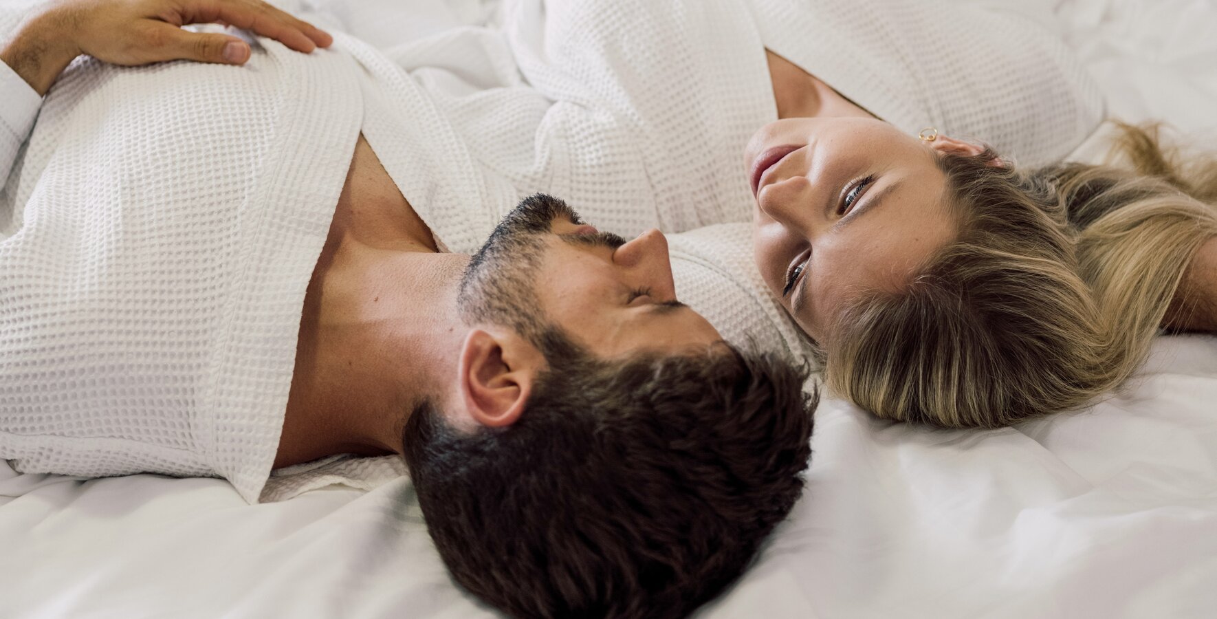 Paar entspannt gemütlich mit dem Bademantel im Bett des 4*S Hotels im Spa Resort Geinberg | © Spa Resort Geinberg / Chris Perkles
