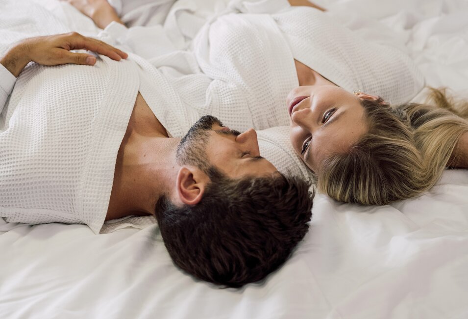 Paar entspannt gemütlich mit dem Bademantel im Bett des 4*S Hotels im Spa Resort Geinberg | © Spa Resort Geinberg / Chris Perkles