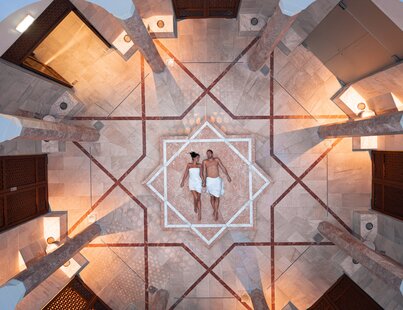 Paar am sternenförmigen Nabelstein in der Oriental World im Spa Resort Geinberg aus der Vogelperspektive  | © Spa Resort Geinberg / Tobi Gast