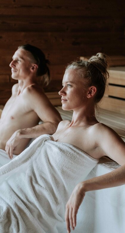 Eine Dame und ein Herr beim Saunaaufguss | © Spa Resort Geinberg / Tobias Gast