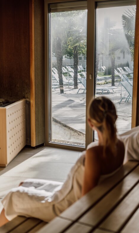 Paar genießt beim Sauna-Besuch die Aussicht auf die Strandfläche der Karibischen Saunawelt im Spa Resort Geinberg | © Spa Resort Geinberg / Chris Perkles
