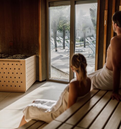 Paar genießt beim Sauna-Besuch die Aussicht auf die Strandfläche der Karibischen Saunawelt im Spa Resort Geinberg | © Spa Resort Geinberg / Chris Perkles