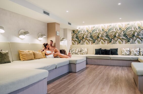 Paar in Handtüchern entspannt im grünen Liegebereich der Sauna im Spa Resort Geinberg | © Spa Resort Geinberg / Chris Perkles