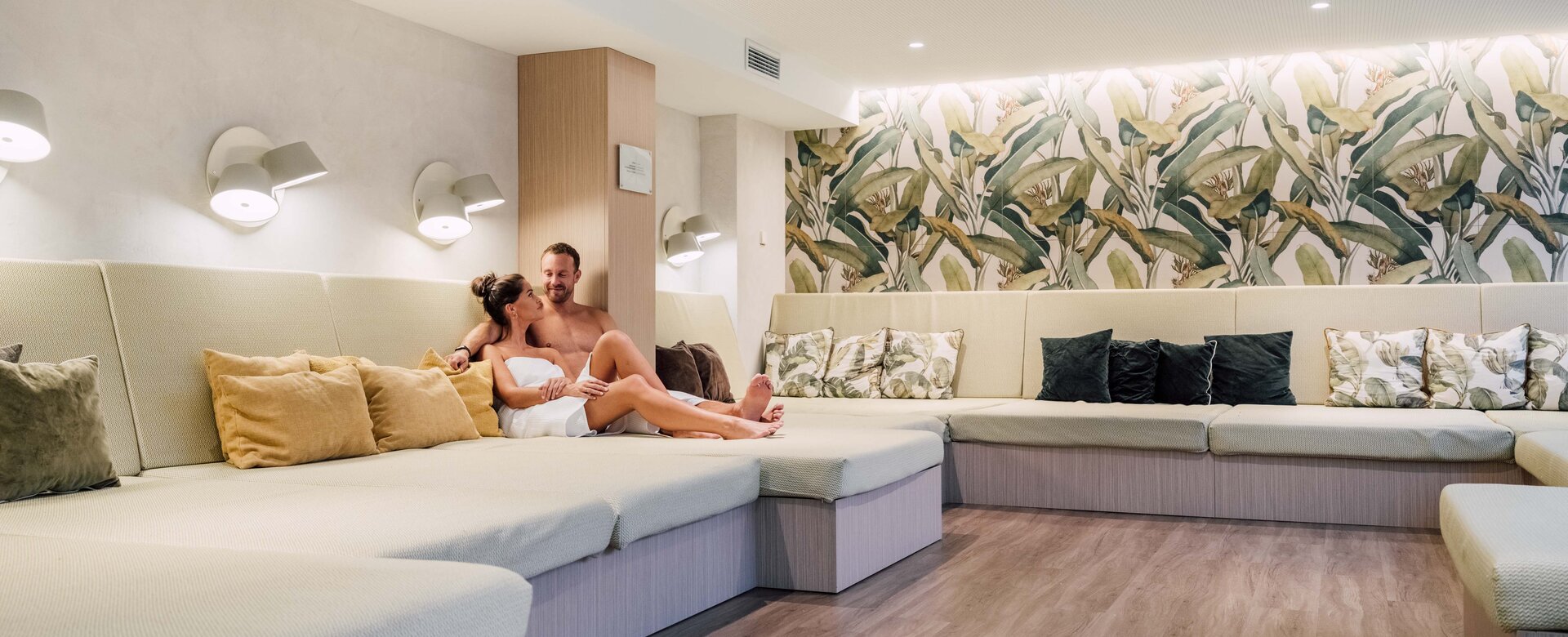 Paar in Handtüchern entspannt im grünen Liegebereich der Sauna im Spa Resort Geinberg | © Spa Resort Geinberg / Chris Perkles