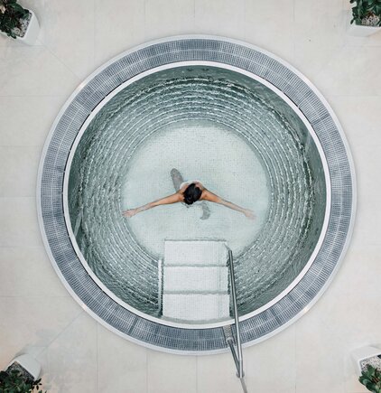 Frau schwimmt im runden Whirlpool der Karibischen Saunawelt im Spa Resort Geinberg | © Spa Resort Geinberg / Chris Perkles