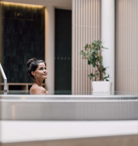 Dunkelhaarige Frau entspannt im Whirlpool in der Karibischen Saunawelt im Spa Resort Geinberg | © Spa Resort Geinberg / Chris Perkles