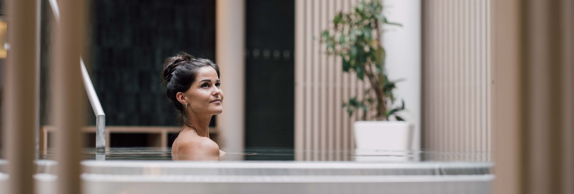 Dunkelhaarige Frau entspannt im Whirlpool in der Karibischen Saunawelt im Spa Resort Geinberg | © Spa Resort Geinberg / Chris Perkles