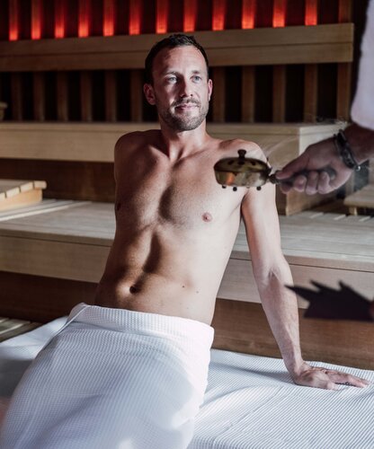 Mann genießt das Sauna-Ritual in der Karibischen Saunawelt im Spa Resort Geinberg | © Spa Resort Geinberg / Chris Perkles