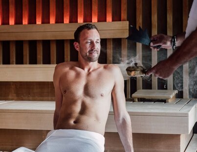 Betörende Aromen beim Sauna-Ritual | © Spa Resort Geinberg / Chris Perkles Mann genießt die Düfte beim Aufguss in der Karibischen Saunawelt des Spa Resort Geinberg | © Spa Resort Geinberg / Chris Perkles