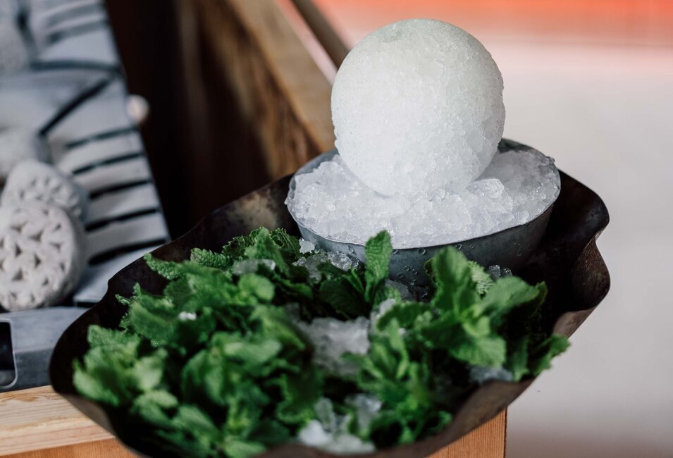 Eiskugel auf Eis, umgeben von Minze in einer Schale | © Spa Resort Geinberg / Chris Perkles