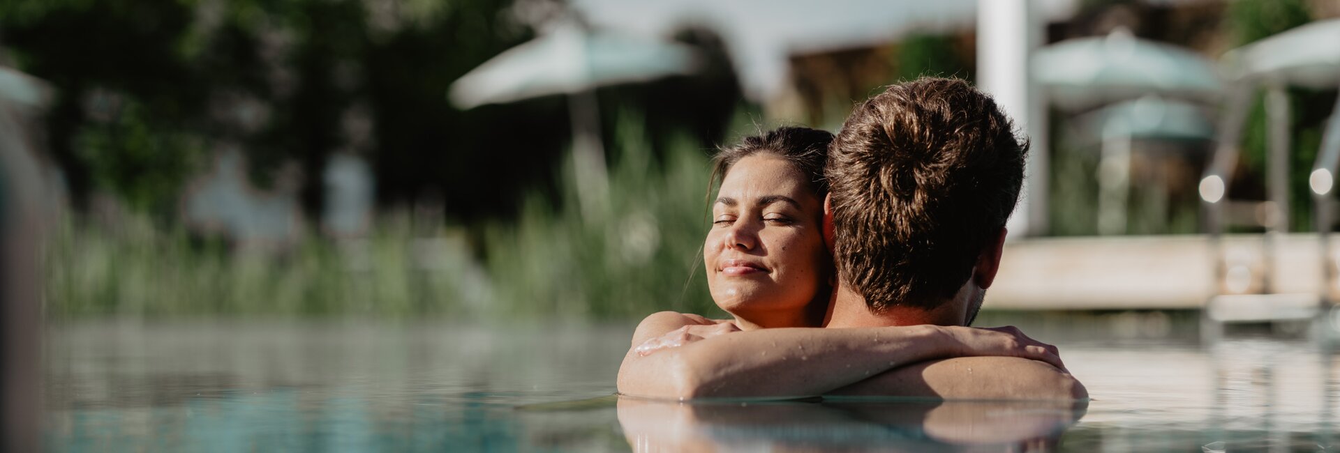 Paar genießt die Sonnenstrahlen im Pool der Karibischen Saunawelt im Spa Resort Geinberg | © Spa Resort Geinberg / Chris Perkles