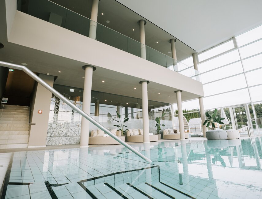 Heller Spa-Bereich mit Indoor-Pool und bequemen Liegebereichen mit Designer-Daybeds | © Spa Resort Geinberg / Tobi Gast