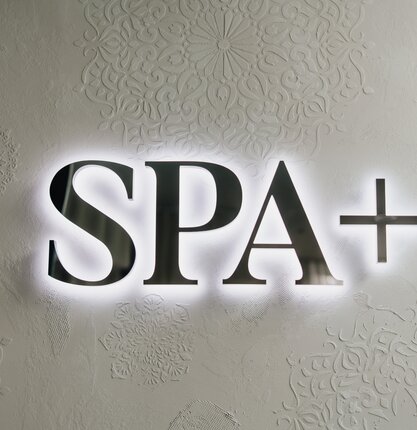 Hinterleuchtetes SPA+ Schild des Spa Resort Geinberg | © Spa Resort Geinberg / Tobi Gast