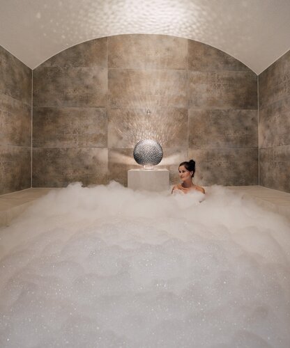 Entspannte Frau in luxuriösem Schaumbad mit Lampe | © Spa Resort Geinberg / Chris Perkles