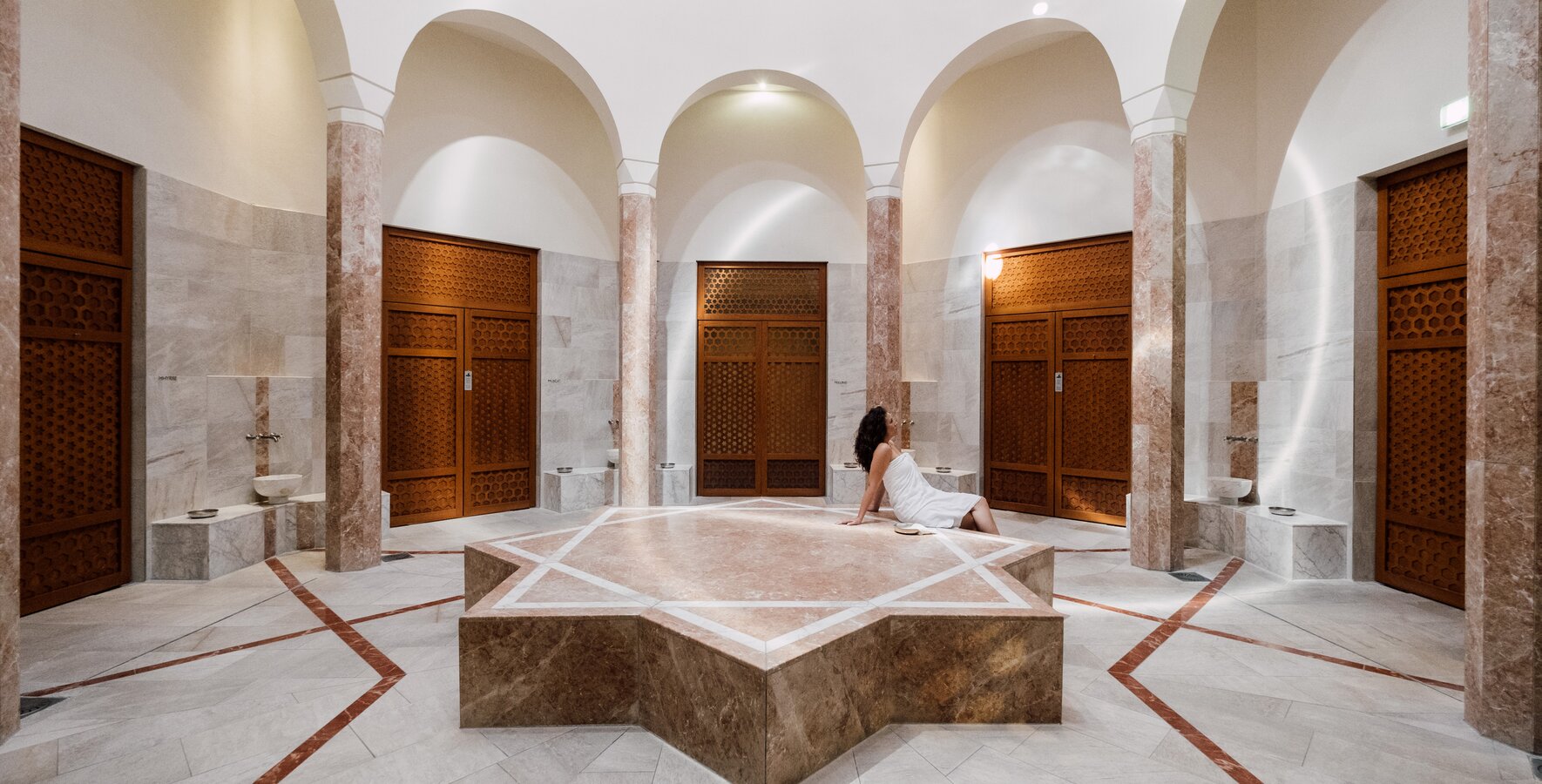 Urlauberin entspannt am warmen Nabelstein in der Oriental World des Spa Resort Geinberg | © Spa Resort Geinberg / Chris Perkles