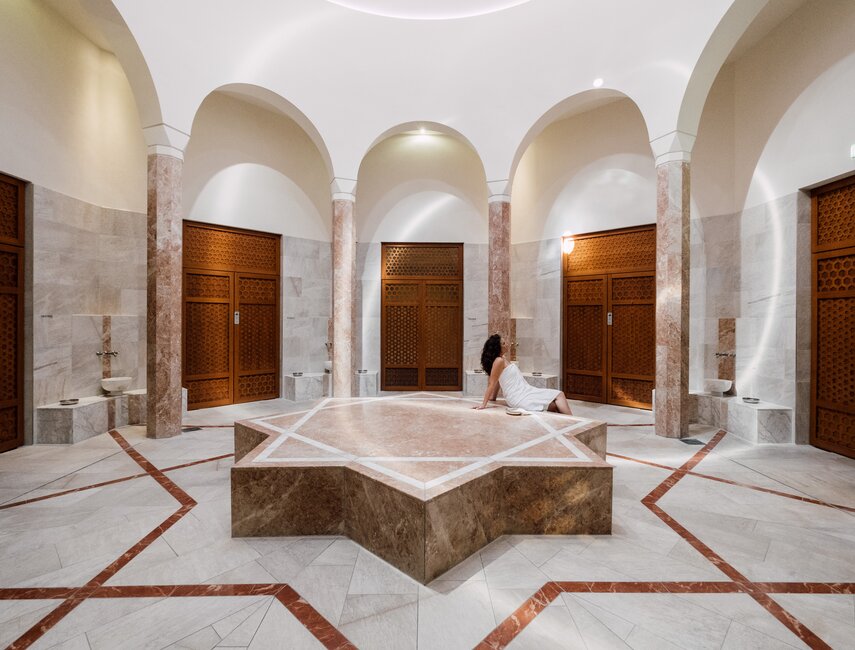 Urlauberin entspannt am warmen Nabelstein in der Oriental World des Spa Resort Geinberg | © Spa Resort Geinberg / Chris Perkles