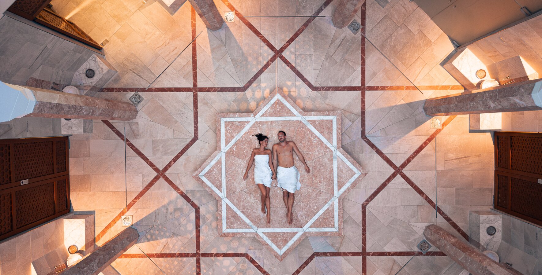 Paar am sternenförmigen Nabelstein in der Oriental World im Spa Resort Geinberg aus der Vogelperspektive  | © Spa Resort Geinberg / Tobi Gast