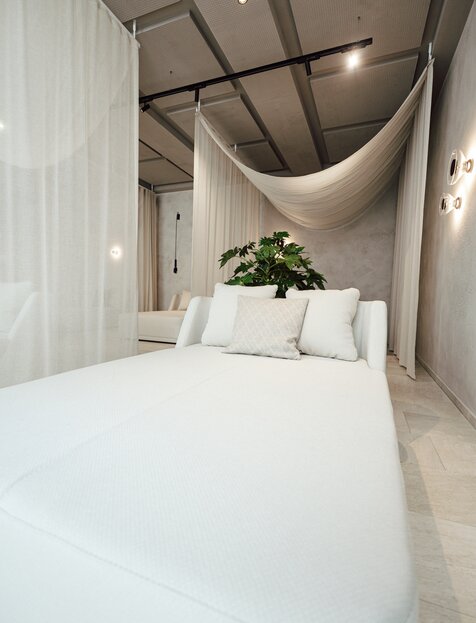 Helles Designer-Daybed im SPAplus-Liegebereich, abgetrennt durch einen Vorhang | © Spa Resort Geinberg / Tobi Gast